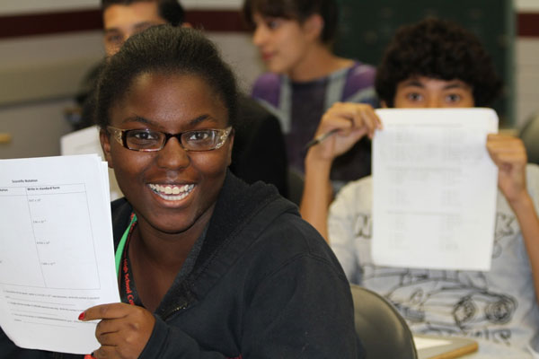 Student smiling holding up graded test